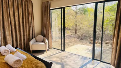a room with a bed and a sliding glass door at Ikigai4617 Villa in Marloth Park