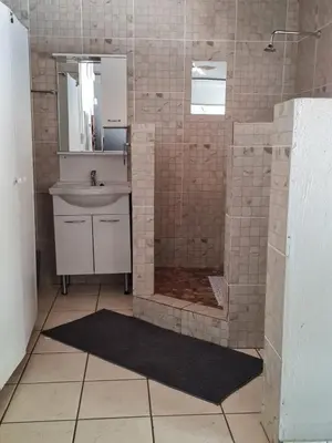 a bathroom with a shower and a sink at Singwe Private Safari Lodge Kruger in Marloth Park