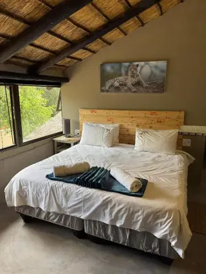 a bedroom with a large bed with towels on it at Singwe Private Safari Lodge Kruger in Marloth Park
