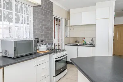 a kitchen with a microwave and a stove top oven at Ikhayalethu in Centurion
