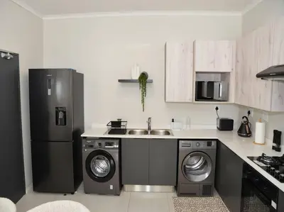 a kitchen with a refrigerator and a washer and dryer at Elcaro Luxury Villas - Urban Taupe 1 in Midrand