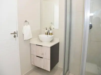 a white bathroom with a sink and a shower at Elcaro Luxury Villas - Urban Taupe 1 in Midrand