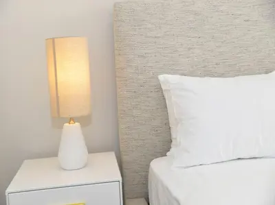 a bedroom with a bed and a lamp on a night stand at Elcaro Luxury Villas - Urban Taupe 1 in Midrand