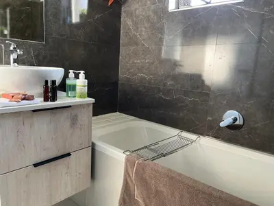 a bathroom with a bath tub and a sink at Cozy Retreat in Carlswald 229 in Midrand