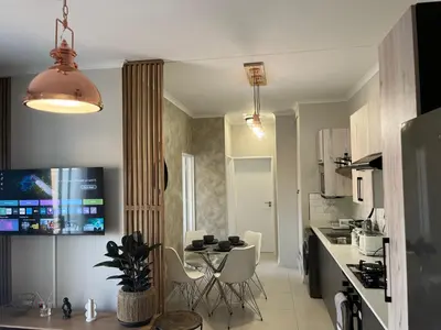 a kitchen with a table and chairs in a room at Cozy Retreat in Carlswald 229 in Midrand