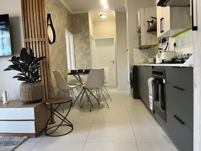 a kitchen with a table and chairs in it at Cozy Retreat in Carlswald 229 in Midrand