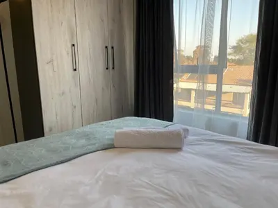 a white bed with a towel on top of it at Cozy Retreat in Carlswald 229 in Midrand