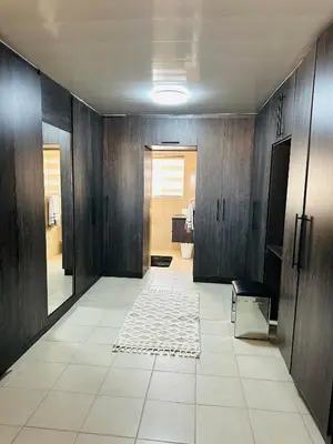 a hallway with a bathroom with wooden walls and a rug at Jobak Farm House in Bela-Bela