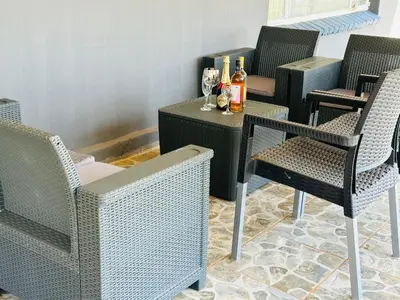 a group of chairs and a table with bottles of wine at Jobak Farm House in Bela-Bela