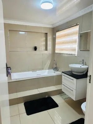 a bathroom with a sink and a bath tub and a sink at Jobak Farm House in Bela-Bela