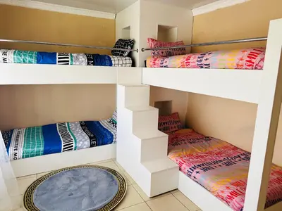 a room with four bunk beds with colorful blankets at Jobak Farm House in Bela-Bela