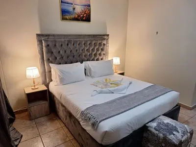 a bedroom with a large bed with a large headboard at Menlyn Place City Vibes in Pretoria