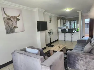 a living room with two couches and a deer head on the wall at Menlyn Place City Vibes in Pretoria