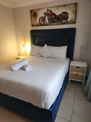 a bedroom with a bed with a motorcycle on the wall at Menlyn Place City Vibes in Pretoria