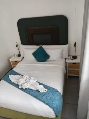 a bedroom with a white bed with a green headboard at Menlyn Place City Vibes in Pretoria