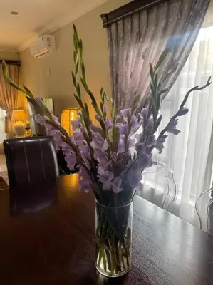 a vase of purple flowers sitting on a table at TG Villa Menlyn in Pretoria