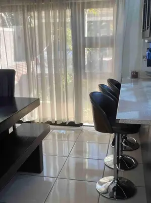 a room with chairs and a table and a window at TG Villa Menlyn in Pretoria