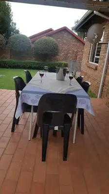a table with wine glasses and chairs on a patio at Dali in Pretoria