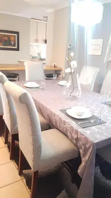 a dining room table with chairs and a white table cloth at Dali in Pretoria