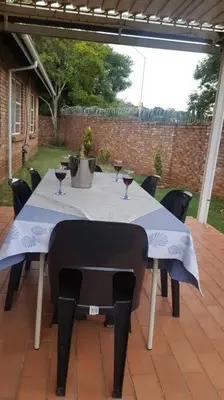 a table with glasses of wine on a patio at Dali in Pretoria