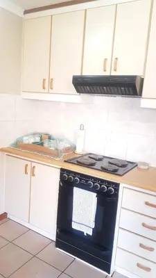 a kitchen with a stove and white cabinets at Dali in Pretoria
