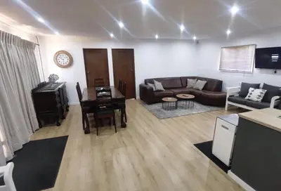 a living room with a couch and a table at Cozy Cabin in Dullstroom