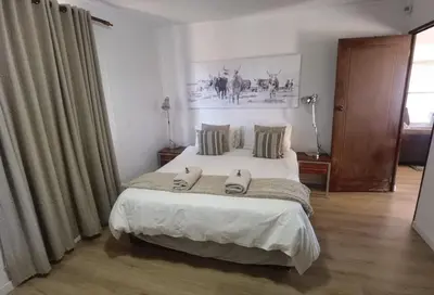 a bedroom with a bed with two slippers on it at Cozy Cabin in Dullstroom