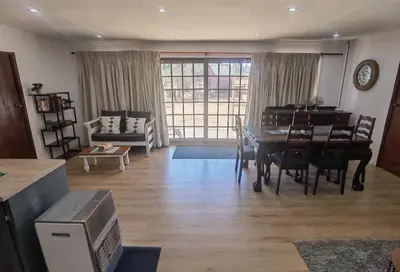 a living room with a table and a piano at Cozy Cabin in Dullstroom