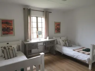 a living room with two beds and a window at Cozy Cabin in Dullstroom