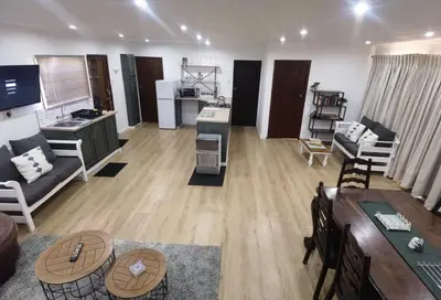 a large living room with a couch and a table at Cozy Cabin in Dullstroom