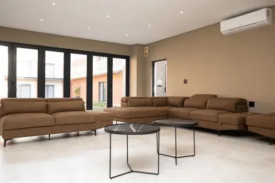 a living room with couches and tables and windows at Kruger Living on Nyati in Malelane