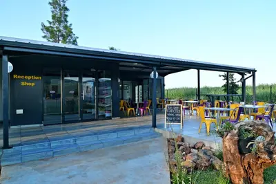 a restaurant with tables and chairs outside of it at SleepOver Malelane in Malelane