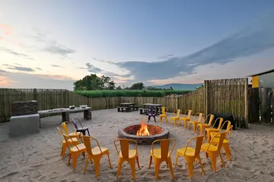 a group of chairs and a fire pit on a patio at SleepOver Malelane in Malelane
