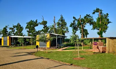 a couple of buildings with trees and a street at SleepOver Malelane in Malelane