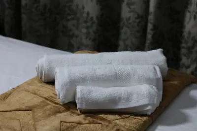 two white towels sitting on top of a bed at Light House Lodge in Bela-Bela