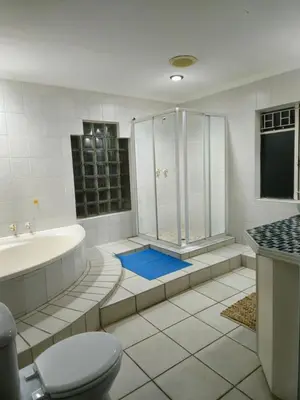 a bathroom with a tub and a shower and a toilet at Light House Lodge in Bela-Bela
