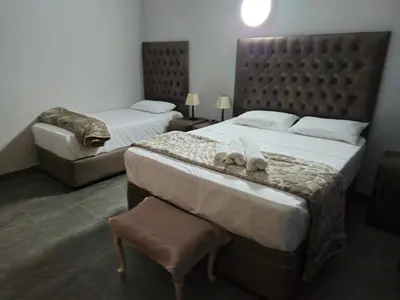 a hotel room with two beds with towels on the bed at Light House Lodge in Bela-Bela