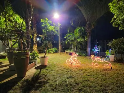 a yard at night with two bicycles decorated with lights at Light House Lodge in Bela-Bela