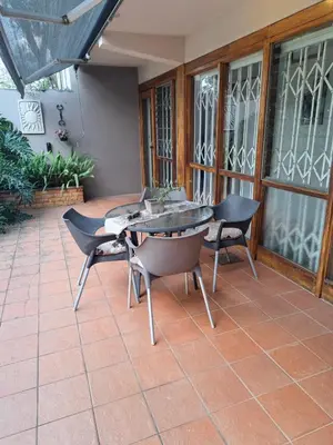 a patio with a table and chairs on a patio at 258 on Aries in Pretoria