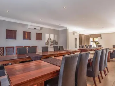 a conference room with wooden tables and chairs at Fairview Manor in Modimolle