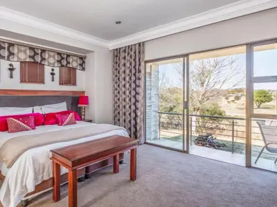 a bedroom with a large bed and a balcony at Fairview Manor in Modimolle
