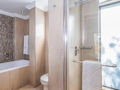 a bathroom with a shower and a toilet and a sink at Fairview Manor in Modimolle
