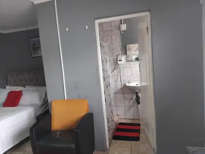 a bedroom with a bed and a bathroom with a sink at Blessing secure unit in Pretoria