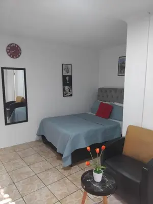 a bedroom with a bed and a couch and a mirror at Blessing secure unit in Pretoria