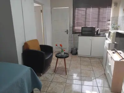a small kitchen with a chair and a table at Blessing secure unit in Pretoria
