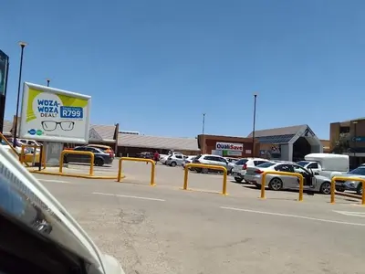 a parking lot with cars parked in front of a store at Welcome Home in Midrand