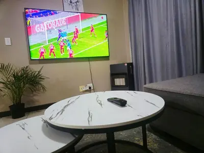 a table in a room with a tv on the wall at Welcome Home in Midrand