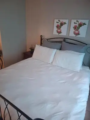 a bed with white sheets and pillows in a bedroom at Pendleberry Grove Holidays in Bela-Bela