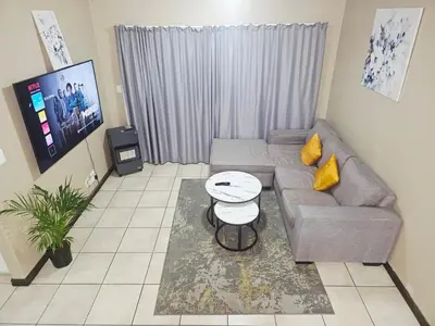 a living room with a couch and a table at Oasis Home in Midrand