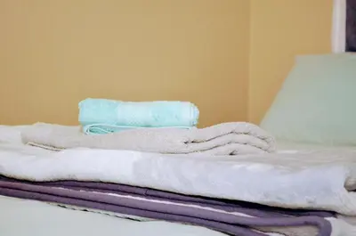 a pile of towels sitting on top of a bed at Oasis Home in Midrand